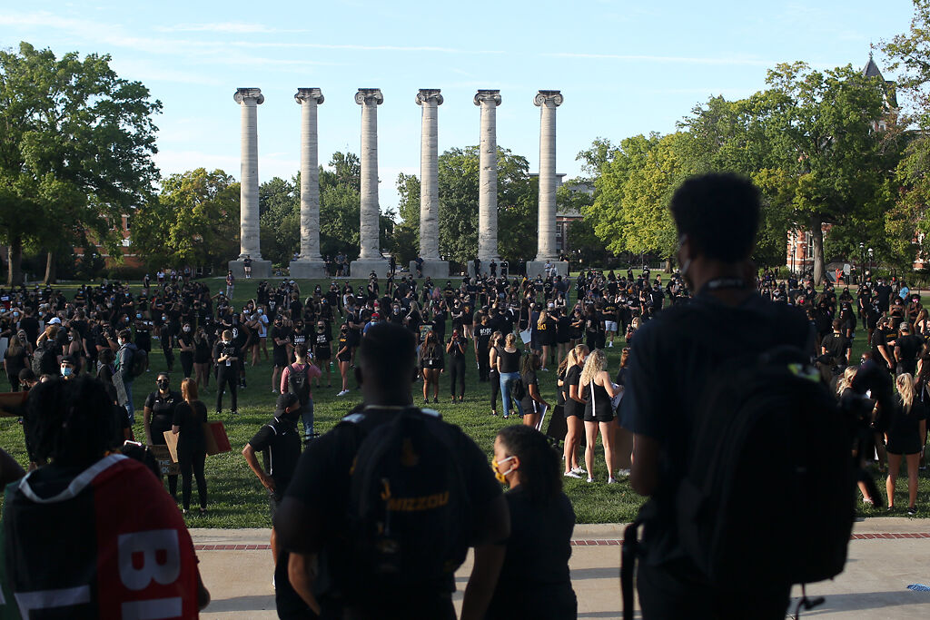 Leaders with MU's Black Student Athletic Association stand on the steps of Jesse Hall